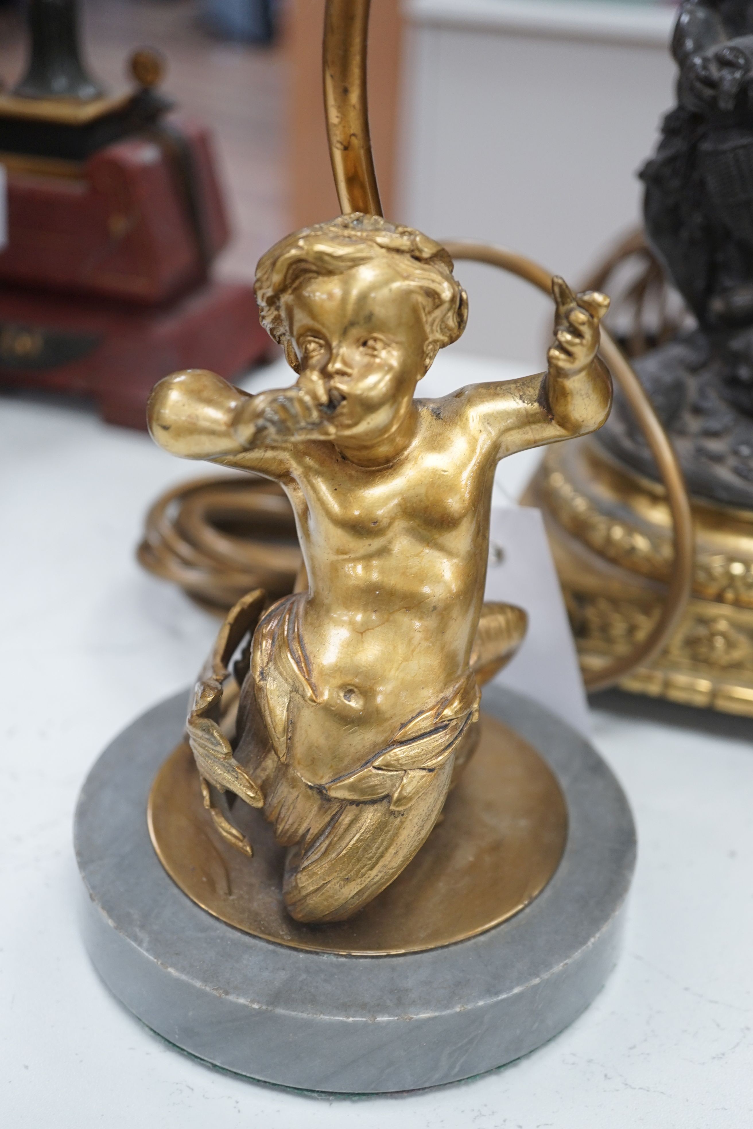 Two bronze or ormolu cherubic table lamps, one with shade. Tallest 58cm total